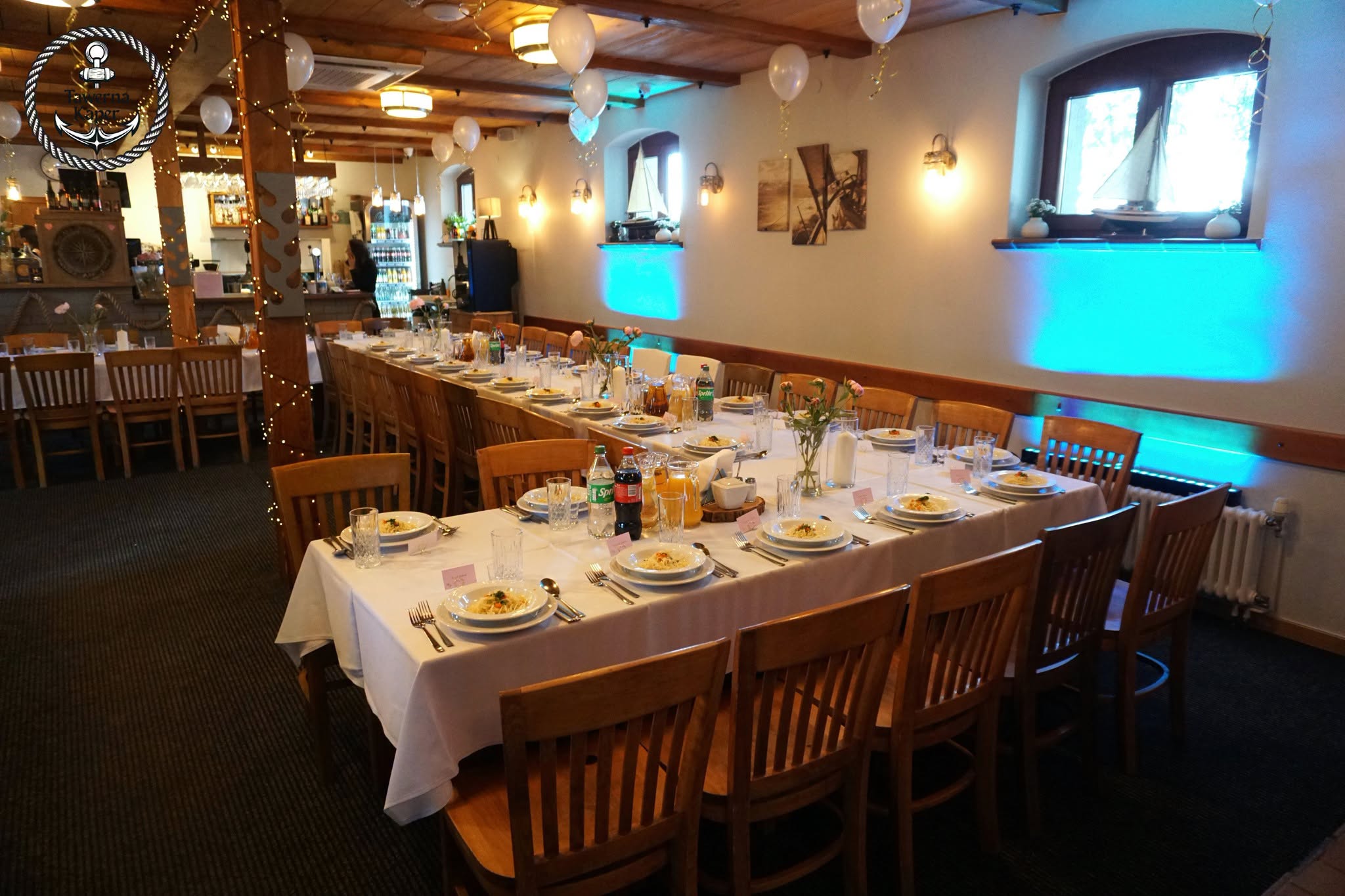 Imprezy okolicznościowe w Imprezy okolicznościowe w Kaperze - elegancko przygotowana sala restauracyjna z zastawionymi stołami